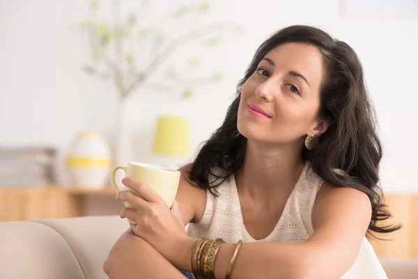 Frau sitzt mit Tasse Tee auf Sofa — Stockfoto