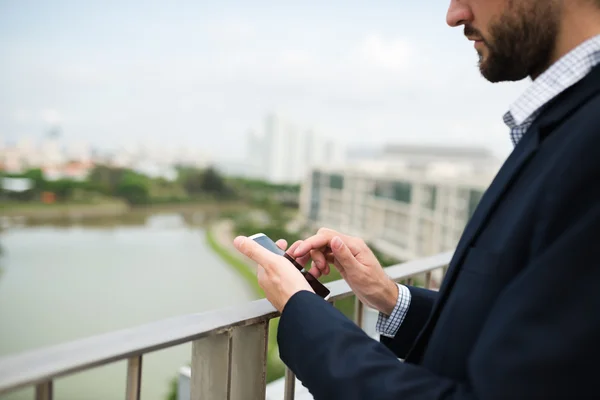 Бізнесмен використовує свій смартфон на відкритому повітрі — стокове фото