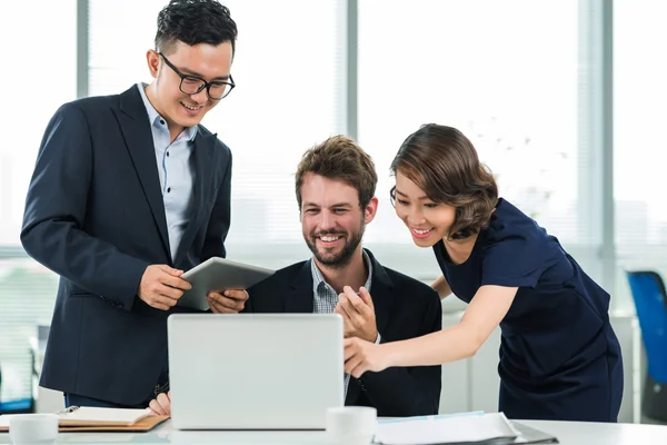 Ofis içinde laptop bakarak iş arkadaşları — Stok fotoğraf