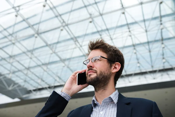 Podnikatel v brýlích mluví po telefonu — Stock fotografie