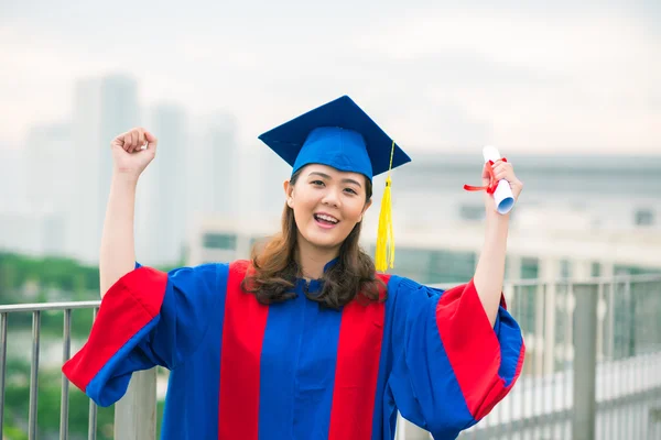 Universitetsexamen i klänning och avläggande av examen hatt — Stockfoto