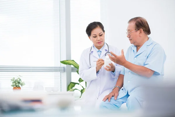 Médico dando pílulas para seu paciente — Fotografia de Stock