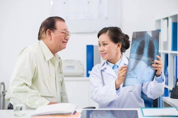 Médico mostrando al hombre los resultados del examen — Foto de Stock