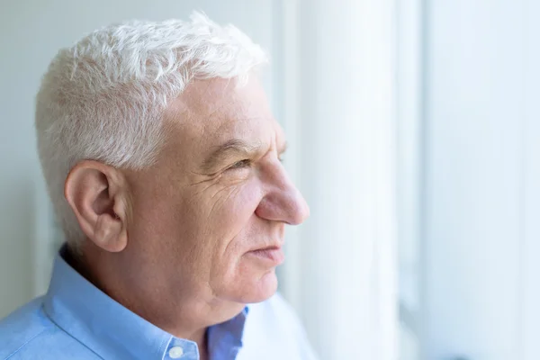 Man tittar genom fönstret — Stockfoto