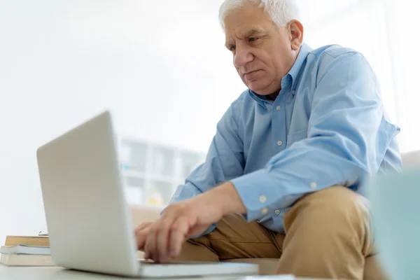 Älterer Mann arbeitet zu Hause — Stockfoto