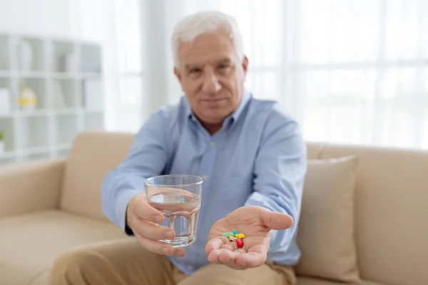 Äldre man med färgglada piller — Stockfoto