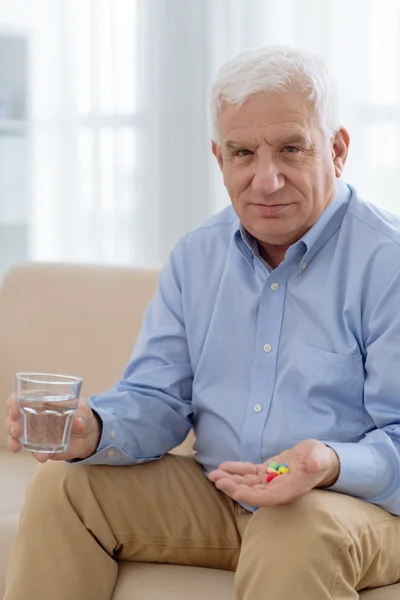 Senior man holding pills — Stock Photo, Image