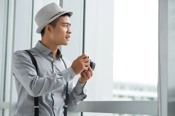 Man looking through window to take photo — Stock Photo, Image