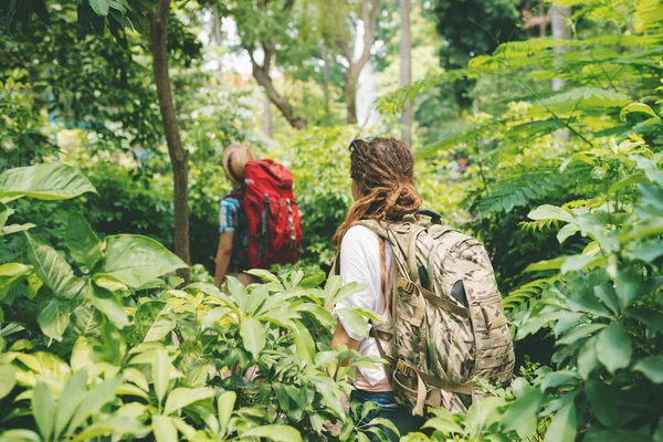 Hombre y mujer con mochilas trekking en el bosque —  Fotos de Stock