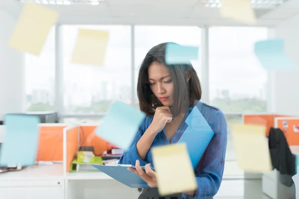 Mujer de negocios mirando portapapeles — Foto de Stock