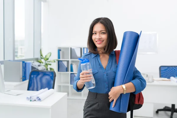 Business woman with exercise mat and water — стоковое фото