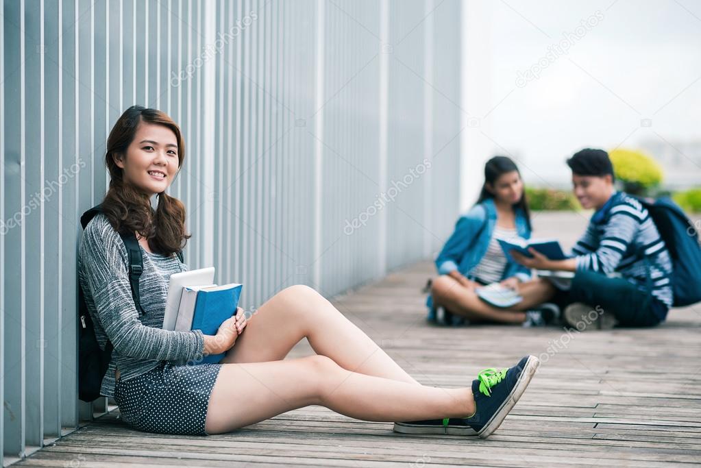 Student girl sitting on floor with  friends