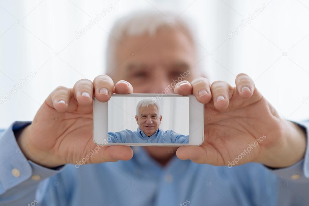 Senior man taking selfie