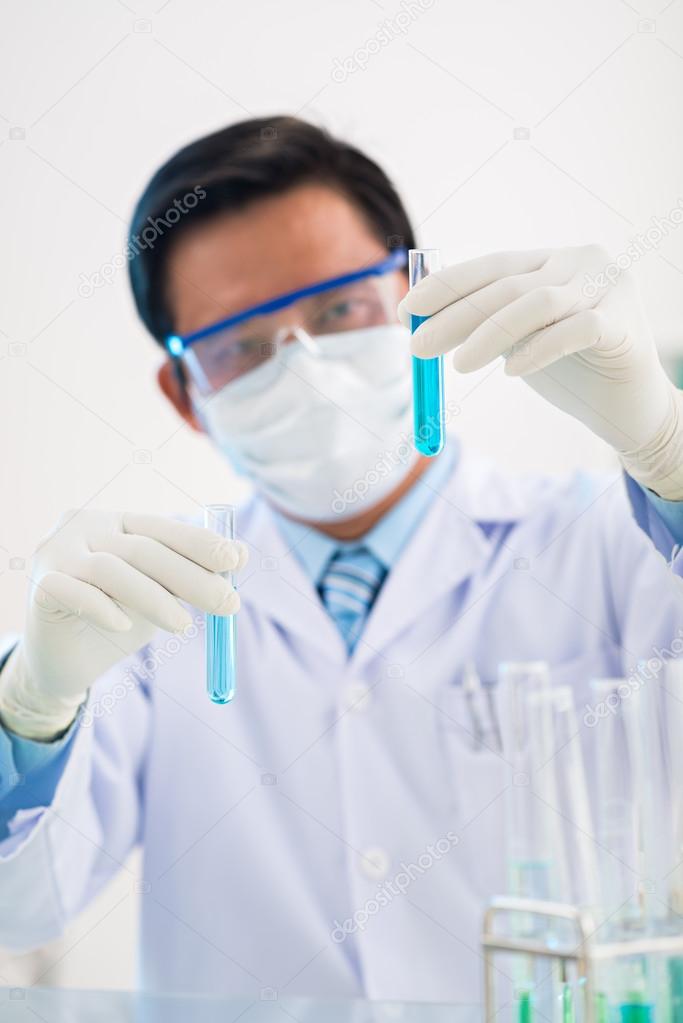 Chemist looking at test-tubes