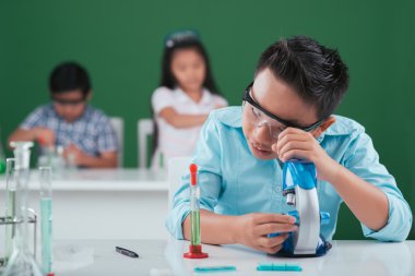 mikroskopla çalışan bir çocuk