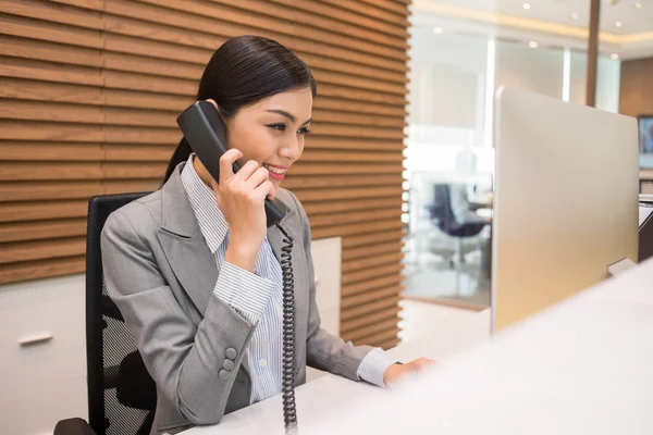 Recepcionista vietnamita falando por telefone — Fotografia de Stock