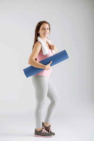 Donna sportiva con tappetino yoga — Foto Stock