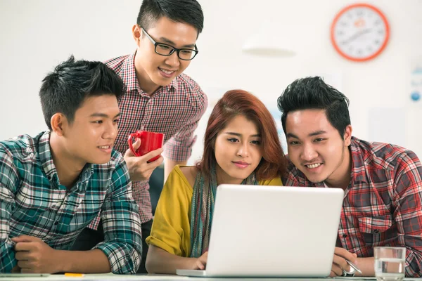 Jovens reunidos em frente ao laptop — Fotografia de Stock