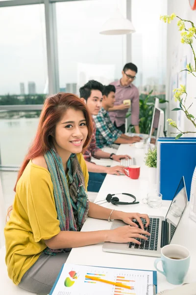 Kvinna som arbetar på laptop på hennes arbetsplats — Stockfoto
