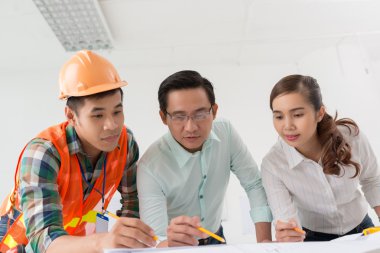 Mimarlar ve yüklenici blueprint tartışıyor