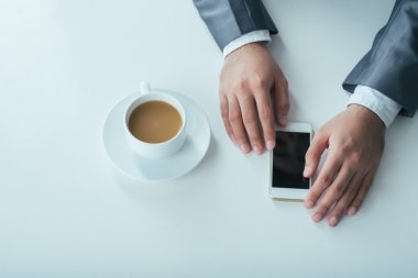 Kahve molası sırasında Smartphone kullanarak iş adamı,