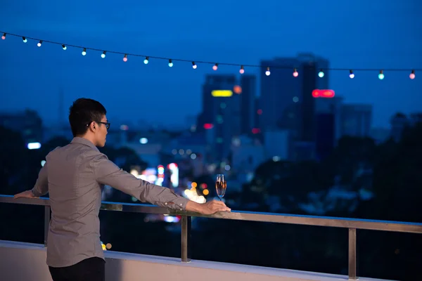 Mężczyzna patrząc na miasto w nocy — Zdjęcie stockowe