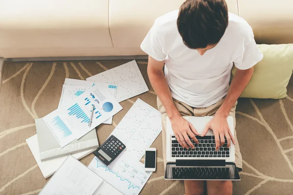 Man sitting on the floor and working on laptop — Stock Photo, Image