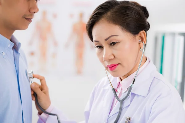 Médico ouvir batimento cardíaco de seu paciente do sexo masculino — Fotografia de Stock