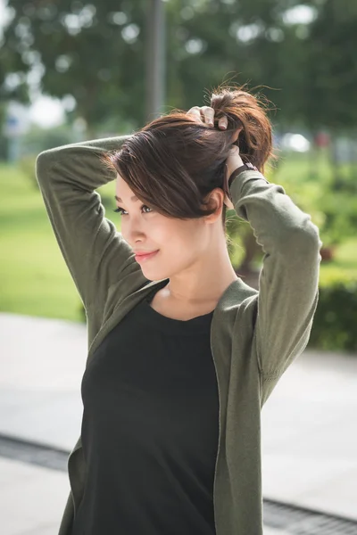 Woman gathering her hair into a ponytail — Stock Photo, Image