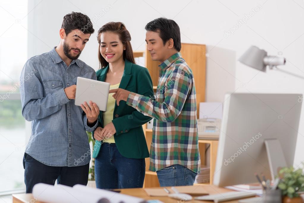 man sharing something on tablet with colleagues