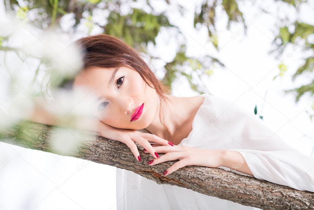 woman leaning against tree  trunk