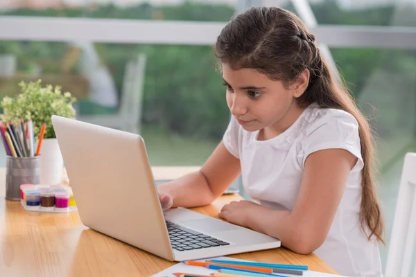 Skolflicka tittar på den bärbara skärmen — Stockfoto