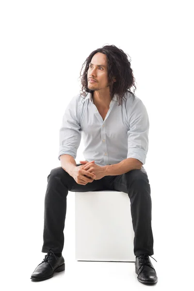 Чоловік сидить на білому кубі — стокове фото