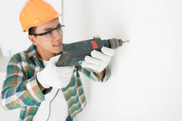 Hombre haciendo agujero en una pared — Foto de Stock