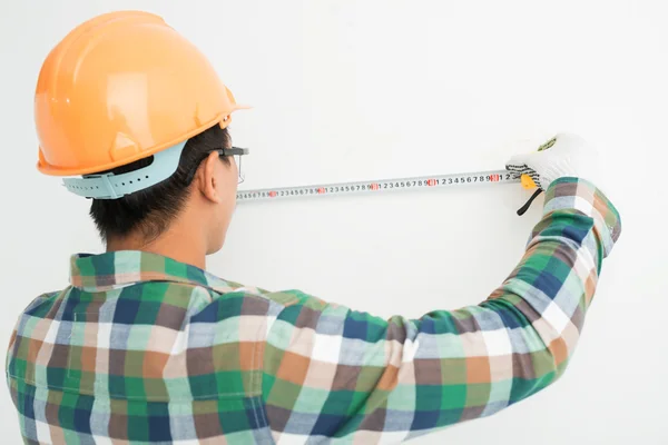 Parede de medição do construtor com uma régua — Fotografia de Stock