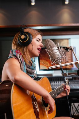 Gitar çalan ve şarkı söyleyen kadın.