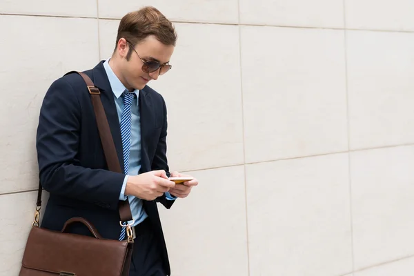 Businessman text messaging outdoors — Stock Photo, Image