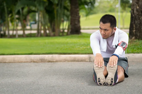 Asiatico uomo stretching gambe — Foto Stock