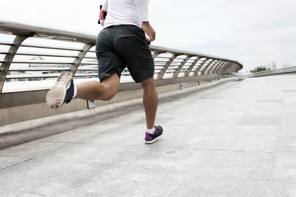 Спортсмен бежит по мосту — стоковое фото