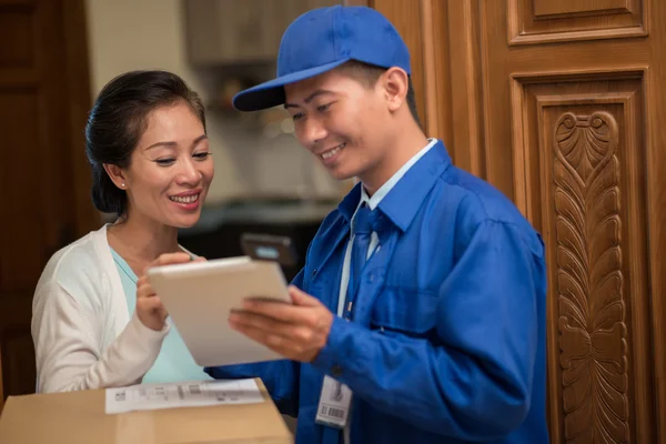 Postman and customer discussing delivery details — Stock Photo, Image