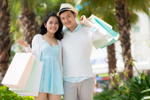 Glada par med papperspåsar — Stockfoto