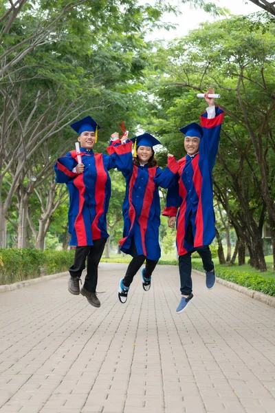 Graduados pulando com felicidade — Fotografia de Stock