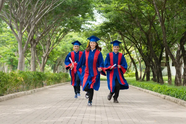 Diplomados com diplomas em execução — Fotografia de Stock