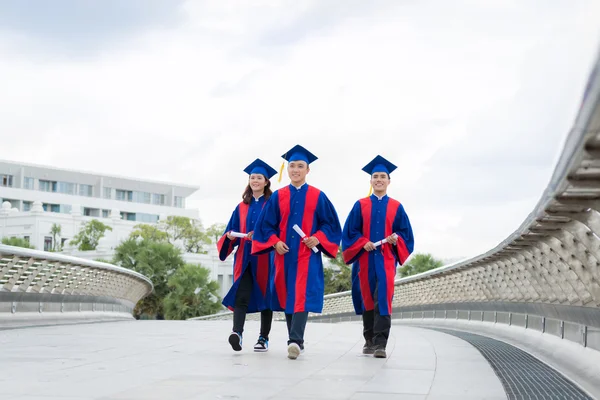 Graduados em vestidos andando — Fotografia de Stock