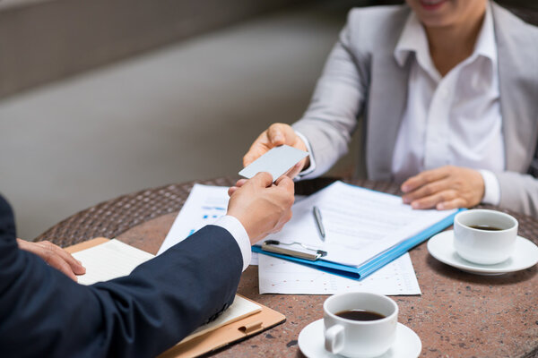 entrepreneur giving business card to colleague