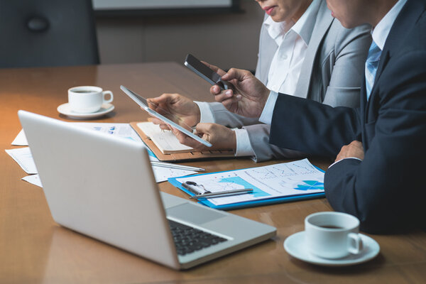 бизнесмены, использующие различные устройства
