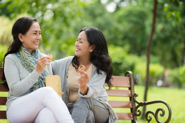 Women eating  on the bench in park — Stock Photo, Image