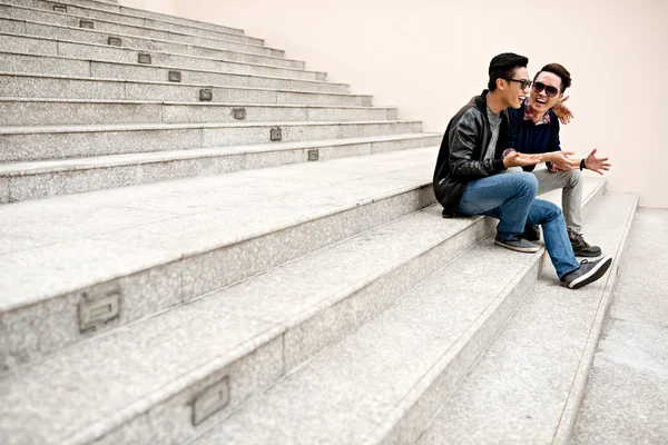 Amigos sentados en las escaleras al aire libre — Foto de Stock