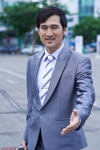 Homem de negócios vietnamita cumprimentando você — Fotografia de Stock