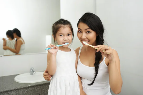 Mãe e filha escovando os dentes — Fotografia de Stock